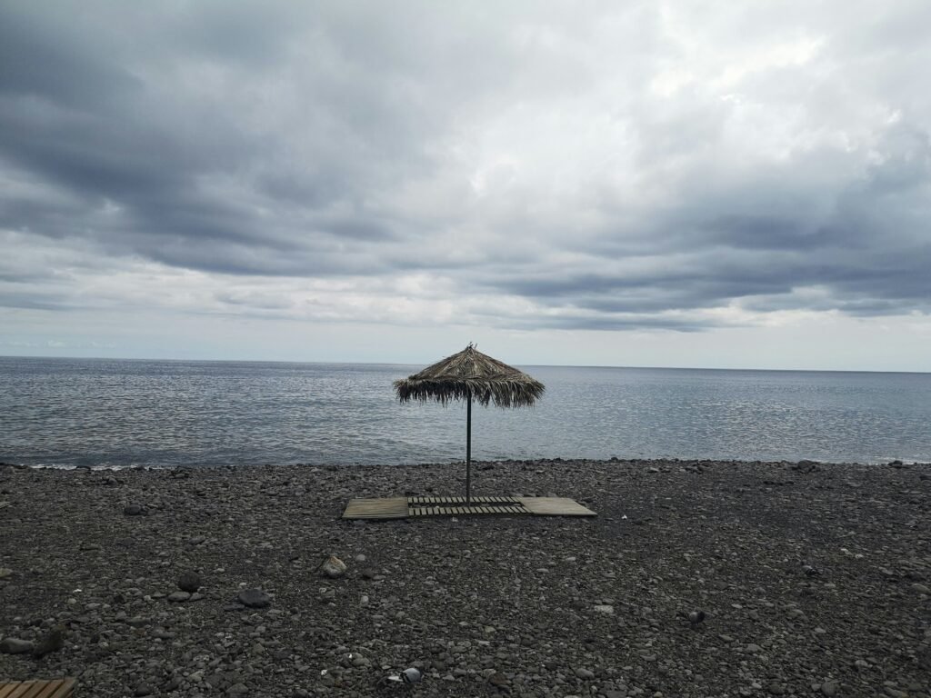 a beach umbrella sitting on top of a sandy beach